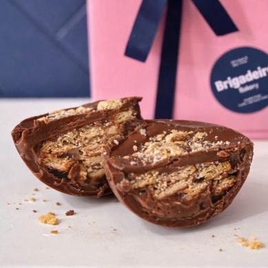 Brigadeiro Bakery: Spoonable Brigadeiro Palha Easter Egg, 3 x $30.00
A half shell of pure milk chocolate filled with creamy brigadeiro and chunks of crunchy Palha (Maria cookie).
This spoonable treat is the perfect mix of smooth chocolate and delightful cookie crunch, making every bite a little moment of joy.

A perfect little treat for family, friends, or yourself—because sometimes, the best treats come in small, spoonable packages!

Weight: approx. 0.44lbs / 210g

Handmade.

Shelf life:
14 days refrigerated.

Important Delivery Info:
We want your treats to arrive fresh, safe, and right on time! To make that happen, please provide a contact name and phone number for the person who will be available during the delivery window. This helps our team coordinate and ensures your order gets to the right hands—no melted chocolate or missed deliveries here!