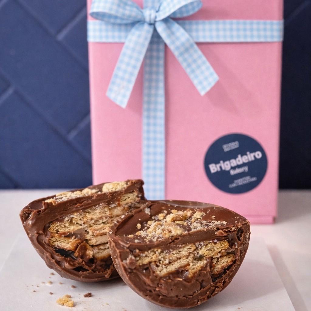 Brigadeiro Bakery: Brigadeiro Palha Easter Egg - half shell, 1 x $16.50
A half shell of pure milk chocolate filled with creamy brigadeiro and chunks of crunchy Palha (Maria cookie).
This spoonable treat is the perfect mix of smooth chocolate and delightful cookie crunch, making every bite a little moment of joy.

A perfect little treat for family, friends, or yourself—because sometimes, the best treats come in small, spoonable packages!

Weight: approx. 0.44lbs / 210g THIS EASTER EGG COMES AS HALF SHELF

Handmade.

Shelf life:
14 days refrigerated.

Important Delivery Info:
We want your treats to arrive fresh, safe, and right on time! To make that happen, please provide a contact name and phone number for the person who will be available during the delivery window. This helps our team coordinate and ensures your order gets to the right hands—no melted chocolate or missed deliveries here!